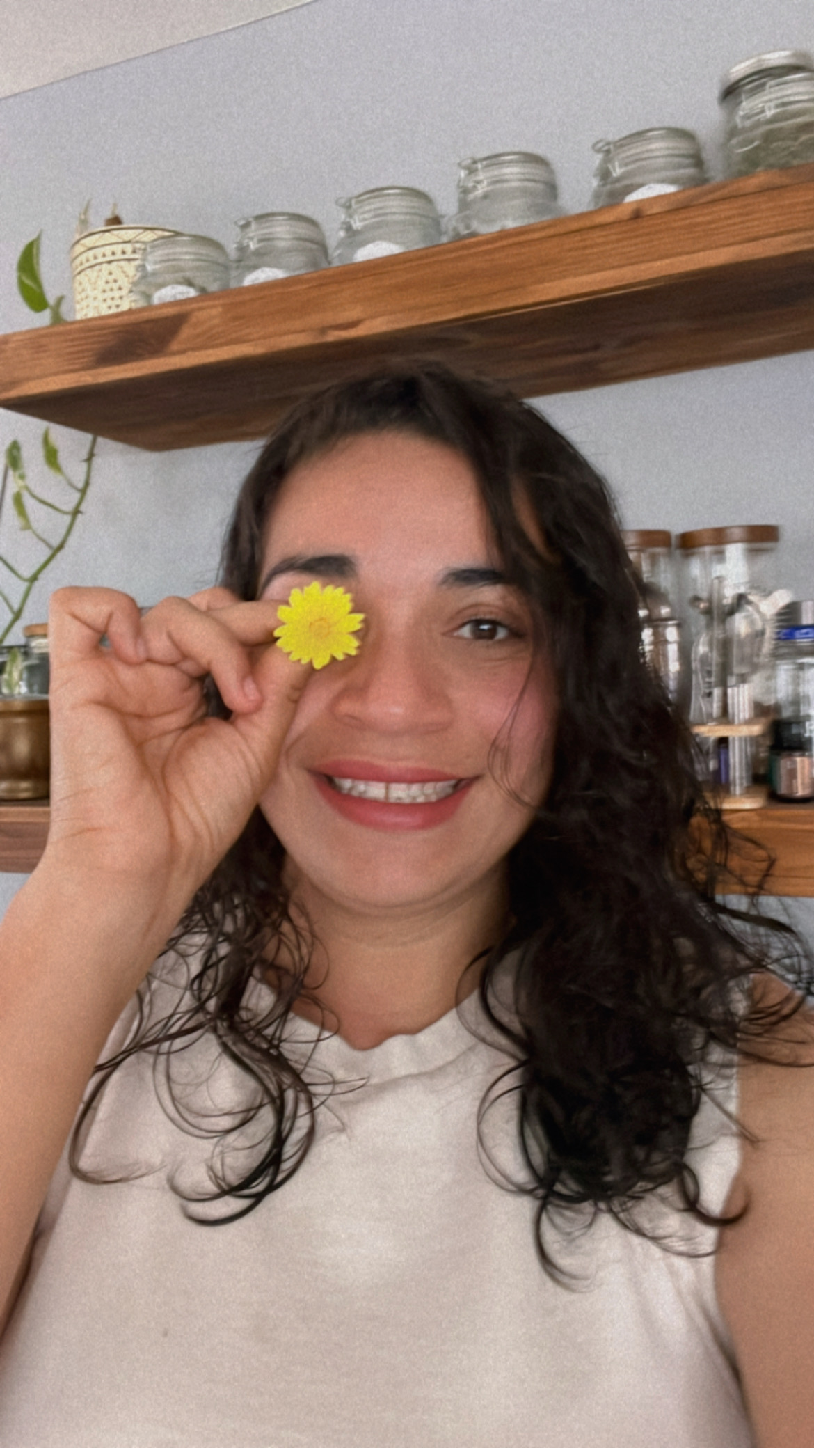 Maritza sosteniendo una flor de caléndula sobre su ojo